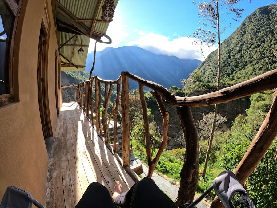 Una terrazza in legno con ringhiera rustica affacciata su un paesaggio montuoso.