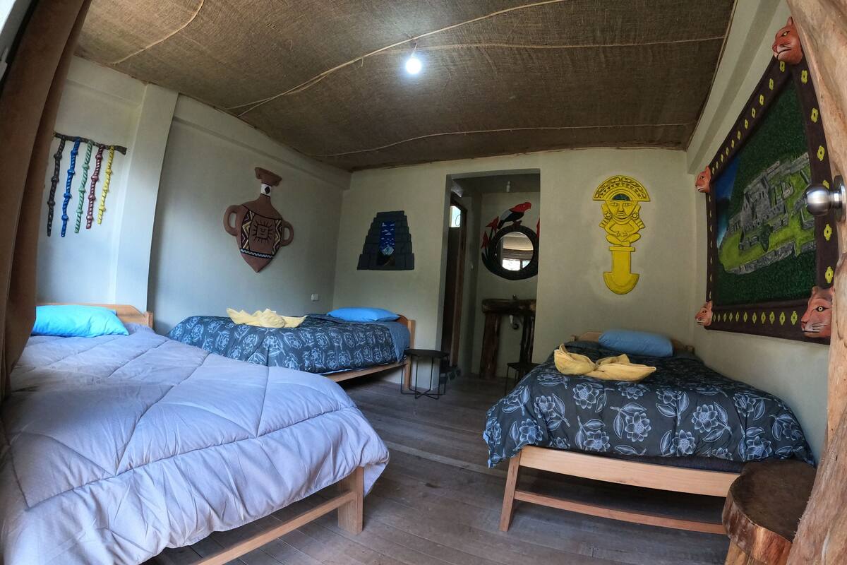 Una stanza con due letti, pavimento in legno e soffitto rustico.
