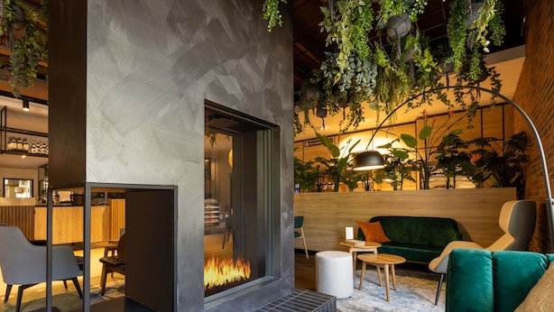 A modern interior with a fireplace, seating area, and indoor plants. - Bungalow in De Peel by Forest Retreat (Vlierden)