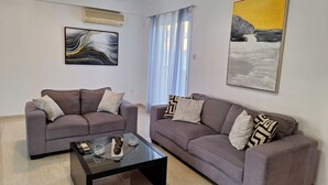 Ein Wohnzimmer mit zwei Sofas, einem Couchtisch und Bildern an den Wänden.