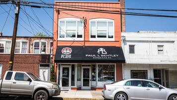 Un edificio de dos pisos con un letrero que indica 'Paul L Bentley Architect A.I.A. P.C.' y 'Bell Sister Flats'.