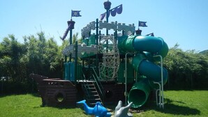 A playground with a pirate-themed play structure, including slides and climbing elements. - Cinque Terre Campsite Chalet 328 Near the sea (Ameglia)