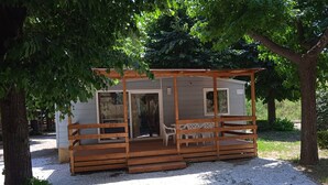 A small wooden cabin with a porch, a door, and a window. - Cinque Terre Campsite Chalet 328 Near the sea (Ameglia)
