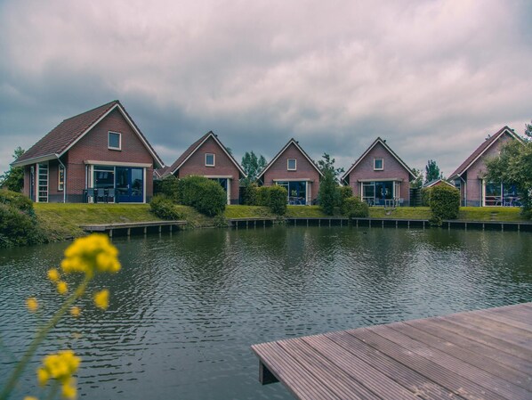 A row of brick houses with a canal in the foreground.