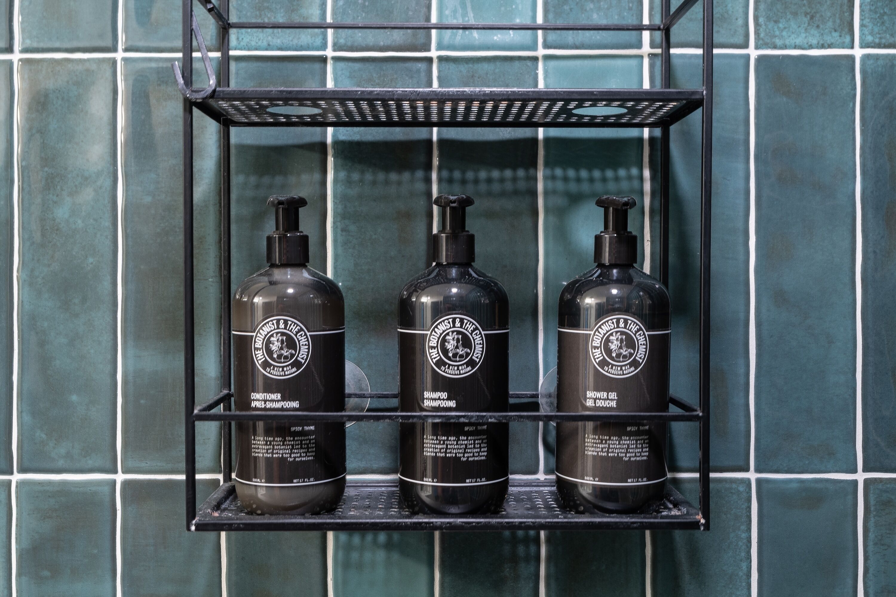 Una estant amb tres amples de productes de la marca The Botanist & The Chemist.