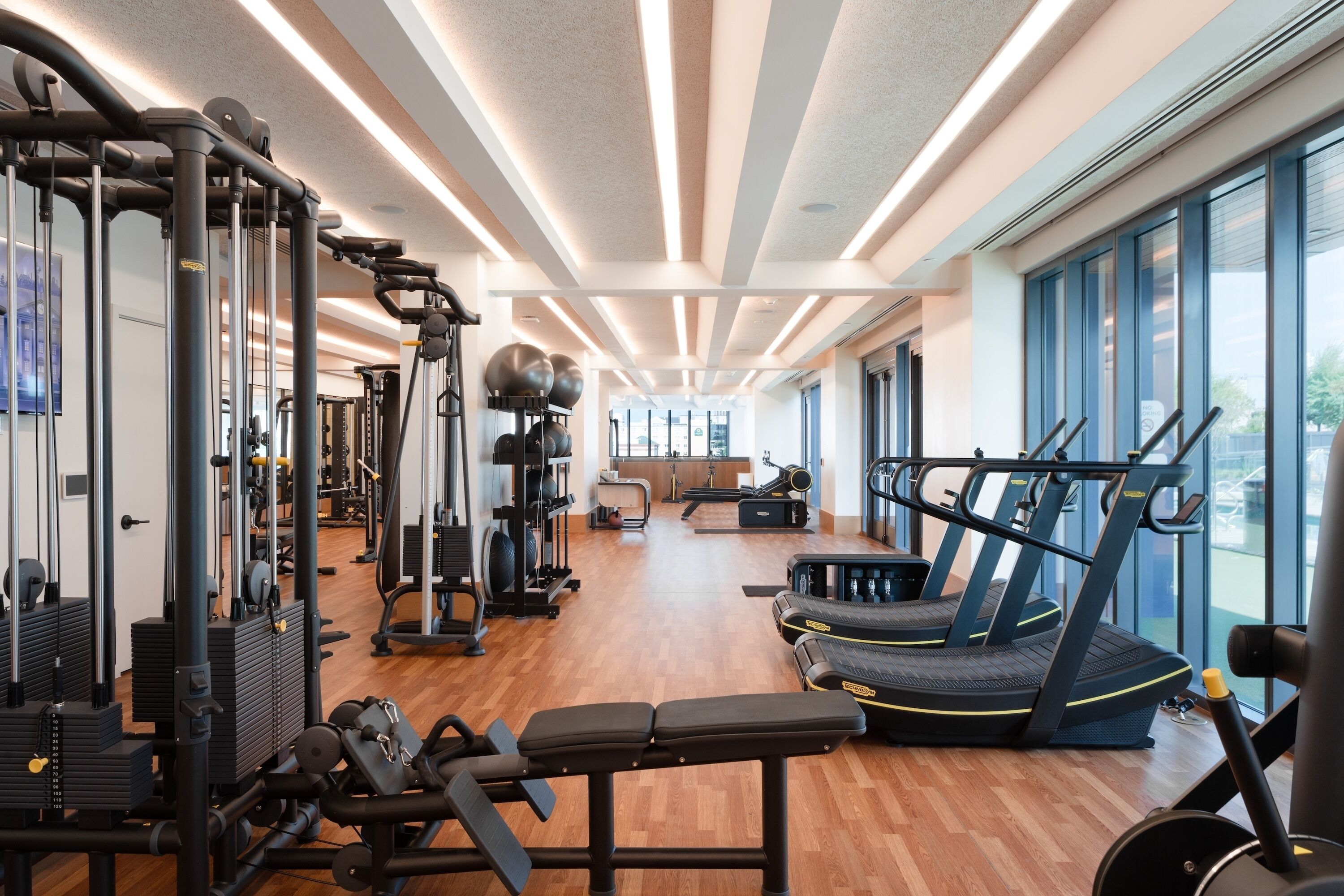 A gym with exercise equipment, a bench, and treadmills.