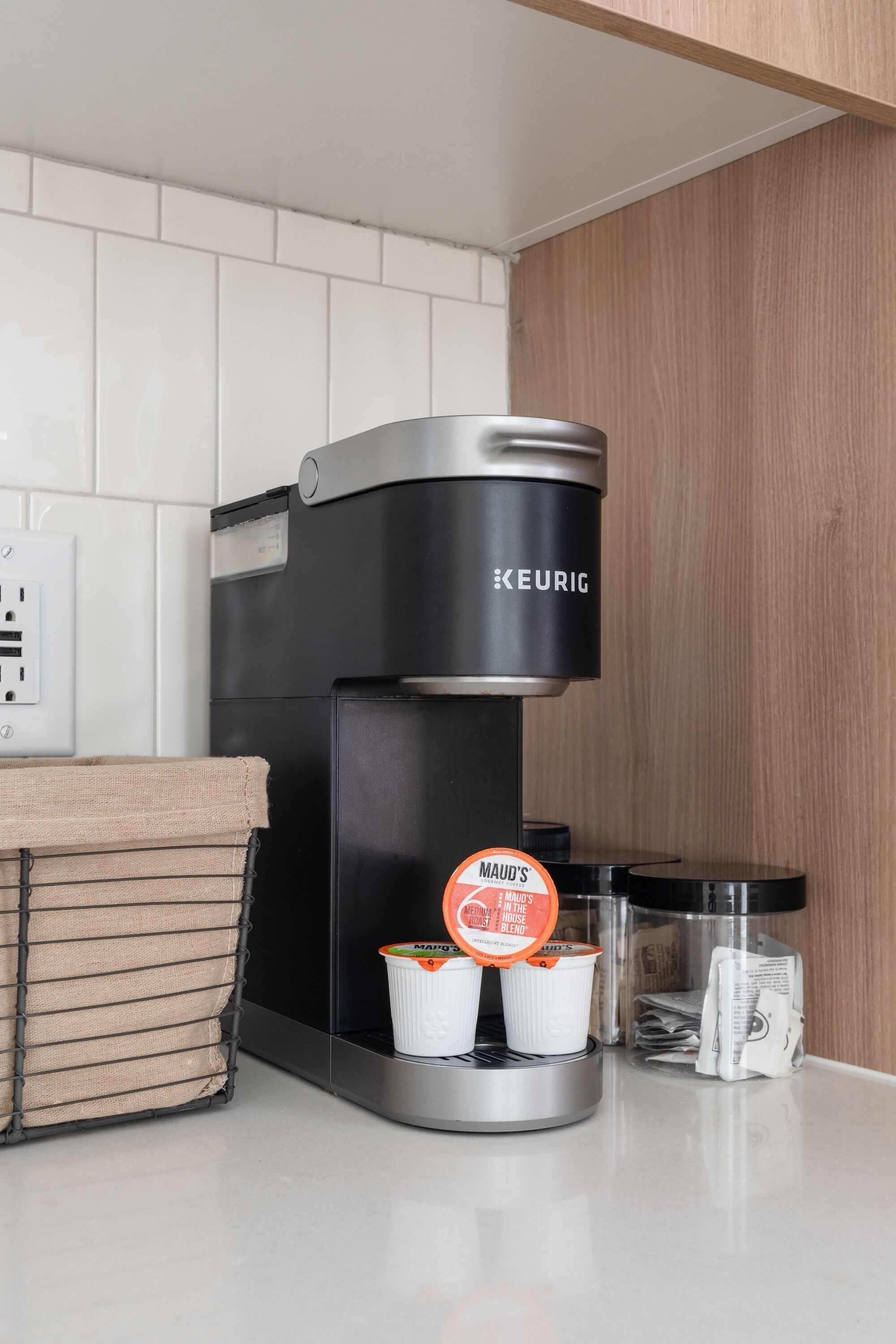 Eine Kaffeemaschine von Keurig mit zwei Einwegbechern und einem Kaffee-Pod-Halter.