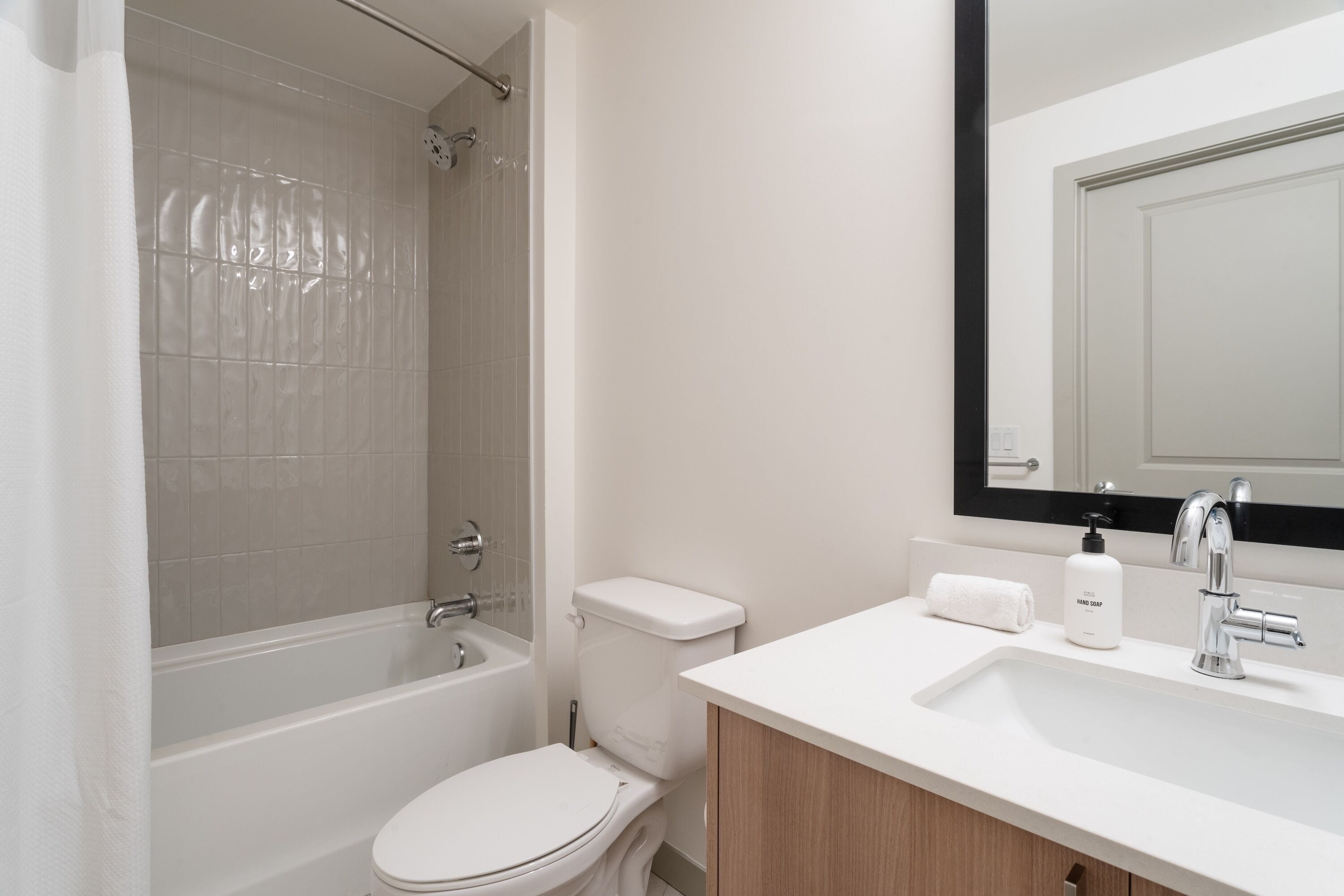 A modern bathroom with a bathtub, toilet, and sink.