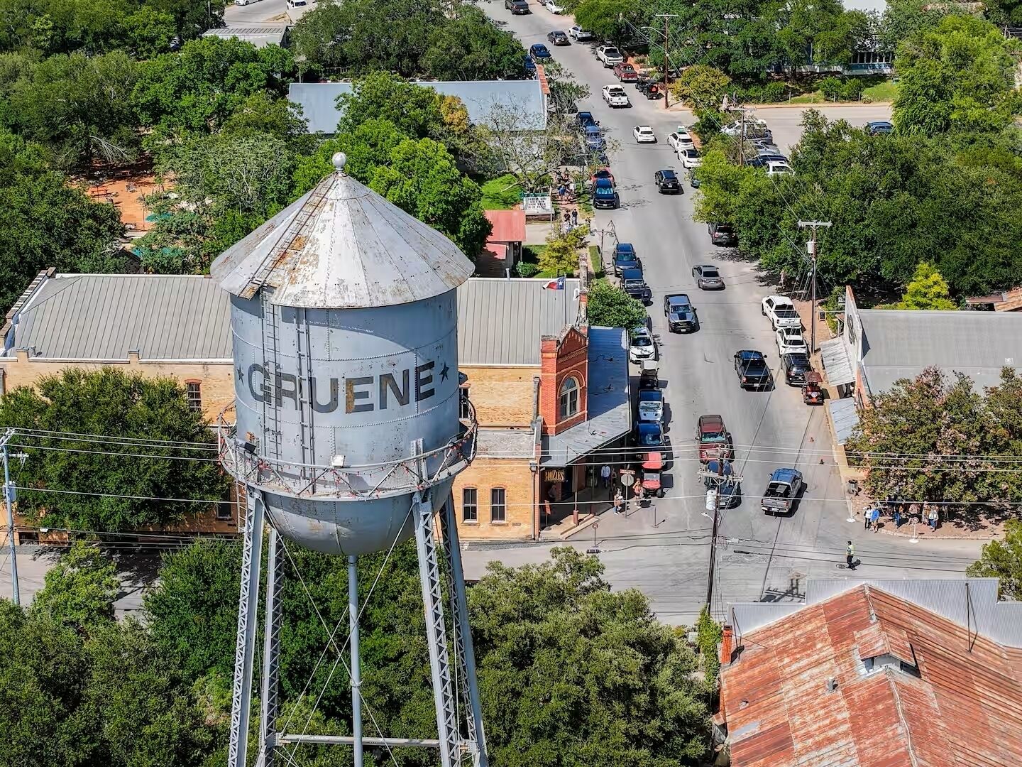 Vista aérea de un pueblo con una destacada torre de agua con la etiqueta 'GRUENE'.