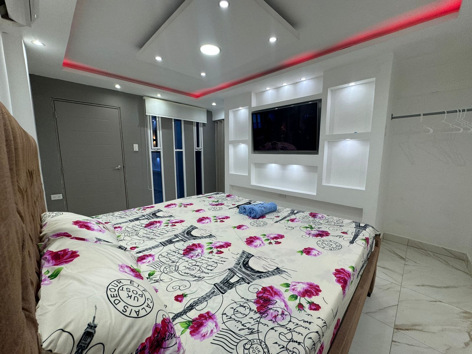 A bedroom with a bed, a TV, and a wardrobe.