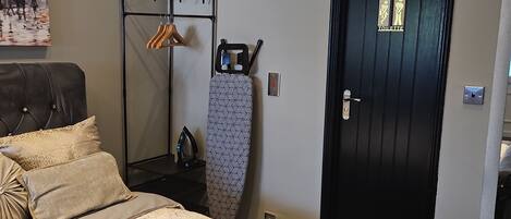 A bedroom with a bed, a wardrobe, a door, and a wall-mounted mirror.