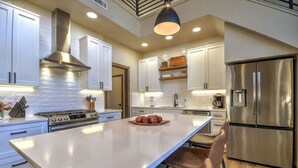 A modern kitchen with white cabinets, stainless steel appliances, and a central island. - Private sauna, close to ski mountain and downtown (Red Lodge)