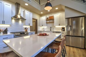 A modern kitchen with white cabinets, stainless steel appliances, and a central island. - Private sauna, close to ski mountain and downtown (Red Lodge)