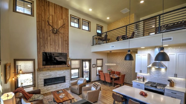 A spacious living area with a fireplace, a dining area, and a kitchen with a large island. - Private sauna, close to ski mountain and downtown (Red Lodge)