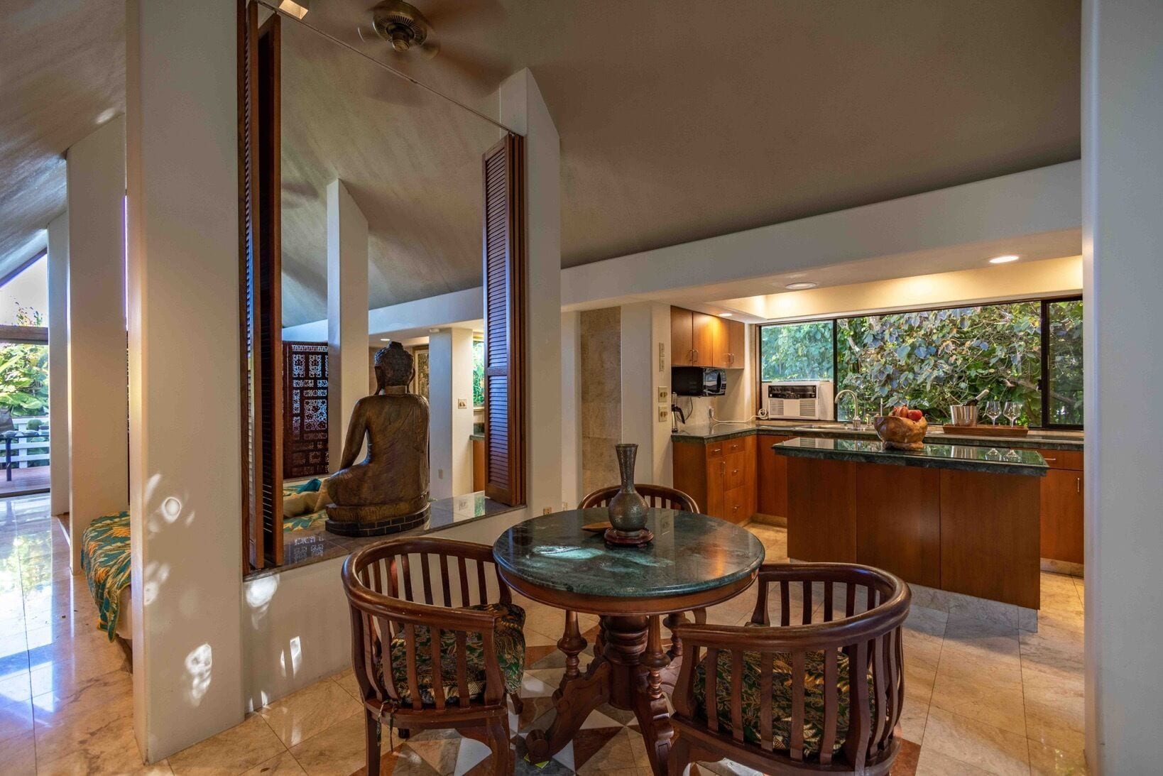 Una cocina moderna con una isla grande, armarios de madera y vistas al exterior.