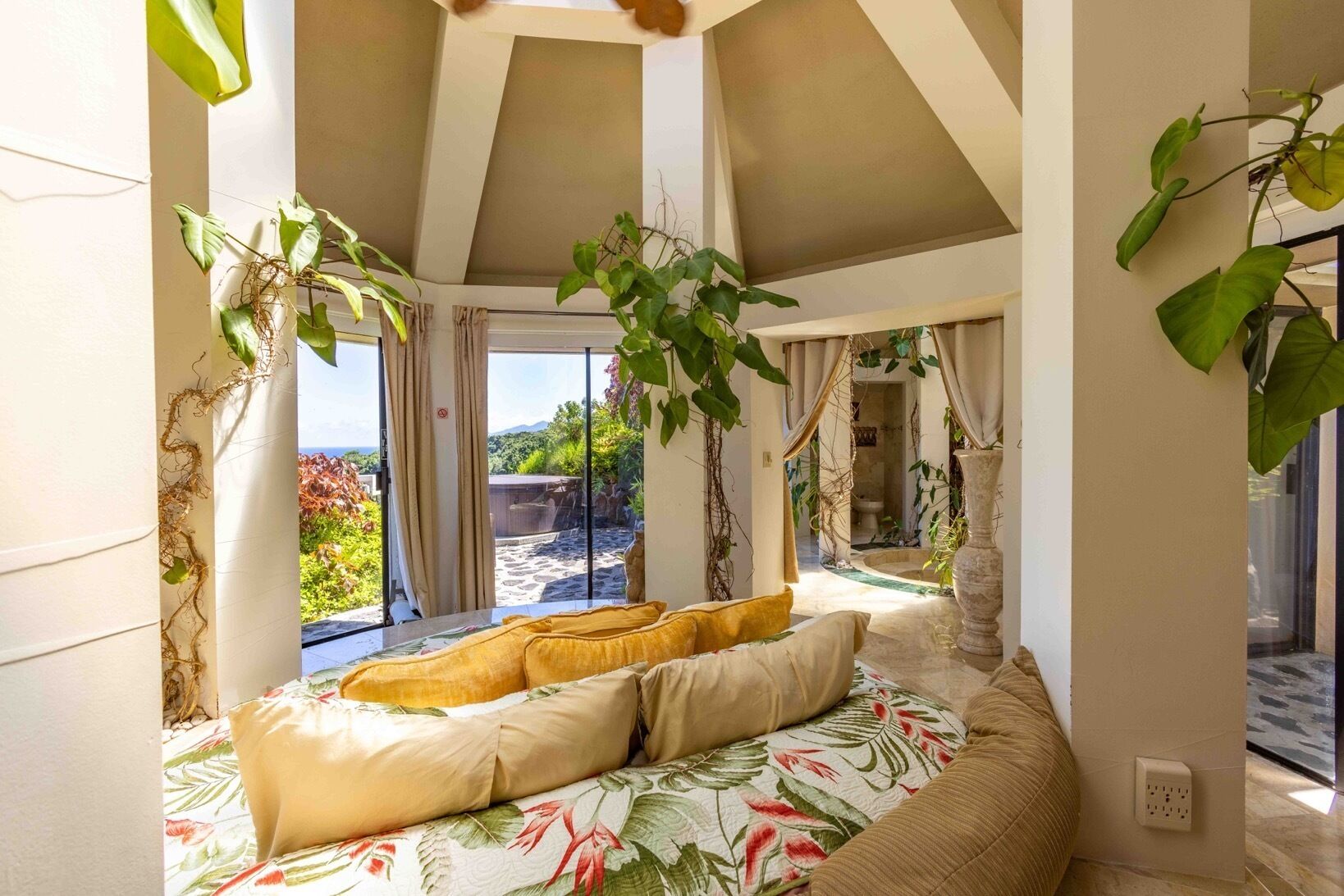 Un dormitorio con cama, cortinas y vista al exterior.