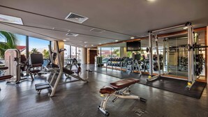 A gym with various exercise equipment, a bench, and a large mirror. - Luxury Waterfront 2BR Condo w/ Pool, Gym & Bar, Puerto Vallarta (Puerto Vallarta)