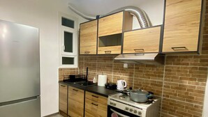 A modern kitchen with wooden cabinets, a stainless steel refrigerator, and a stove. - Sweety flat Marina Zeas Piraeus nearby the sea (Pireas)