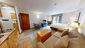 A compact hotel room with a kitchenette, a dining area, a sofa, and a bed. - Hearthstone Lodge #327 (Sun Peaks)