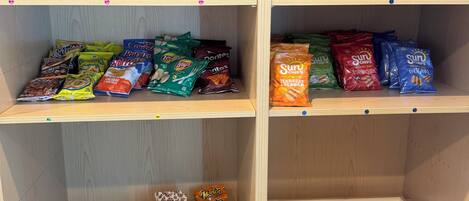 A snack display with various chips and cookies.