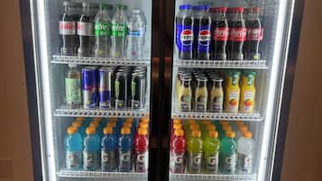 Un refrigerador de doble puerta repleto de bebidas variadas, incluyendo gaseosas, jugos y bebidas energéticas.