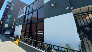 A hotel with a modern facade, large windows, and a visible entrance. - Hotel Rudra - Hollywood (Los Angeles)