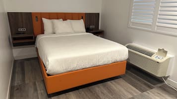 Ein modernes Schlafzimmer mit Bett, Nachttischen und einer Klimaanlage.