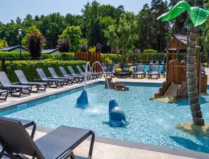A swimming pool with lounge chairs and a dolphin fountain. - Beautiful Chalet With Airco, in a Holiday Park (Veldhoven)