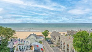 A coastal town with beachfront properties, a clear sky, and a view of the ocean.