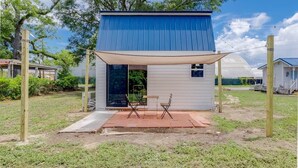 A small, single-story building with a blue roof and a covered patio area. - Tiny House 20 Mins from Beach (Brunswick)