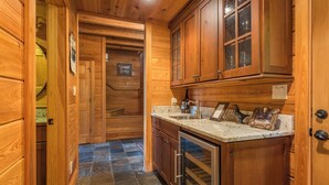 A wooden interior with a kitchen area, including a sink, countertop, and oven. - Grandview Lodge | Large 4 Bedroom Mountain Cabin with Hot Tub & Views! (Old Fort)