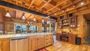 A spacious kitchen with wooden cabinets, a stainless steel dishwasher, and a large island with a sink. - Grandview Lodge | Large 4 Bedroom Mountain Cabin with Hot Tub & Views! (Old Fort)