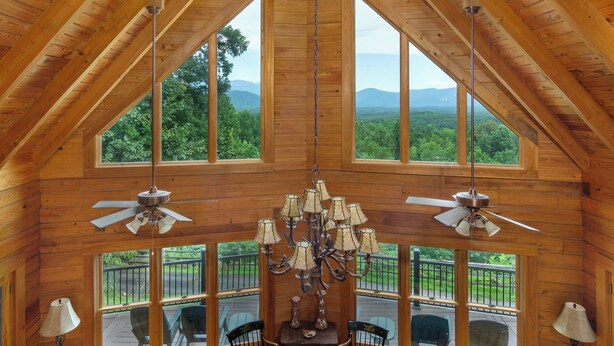 A wooden interior with large windows, a chandelier, and ceiling fans. - Grandview Lodge | Large 4 Bedroom Mountain Cabin with Hot Tub & Views! (Old Fort)