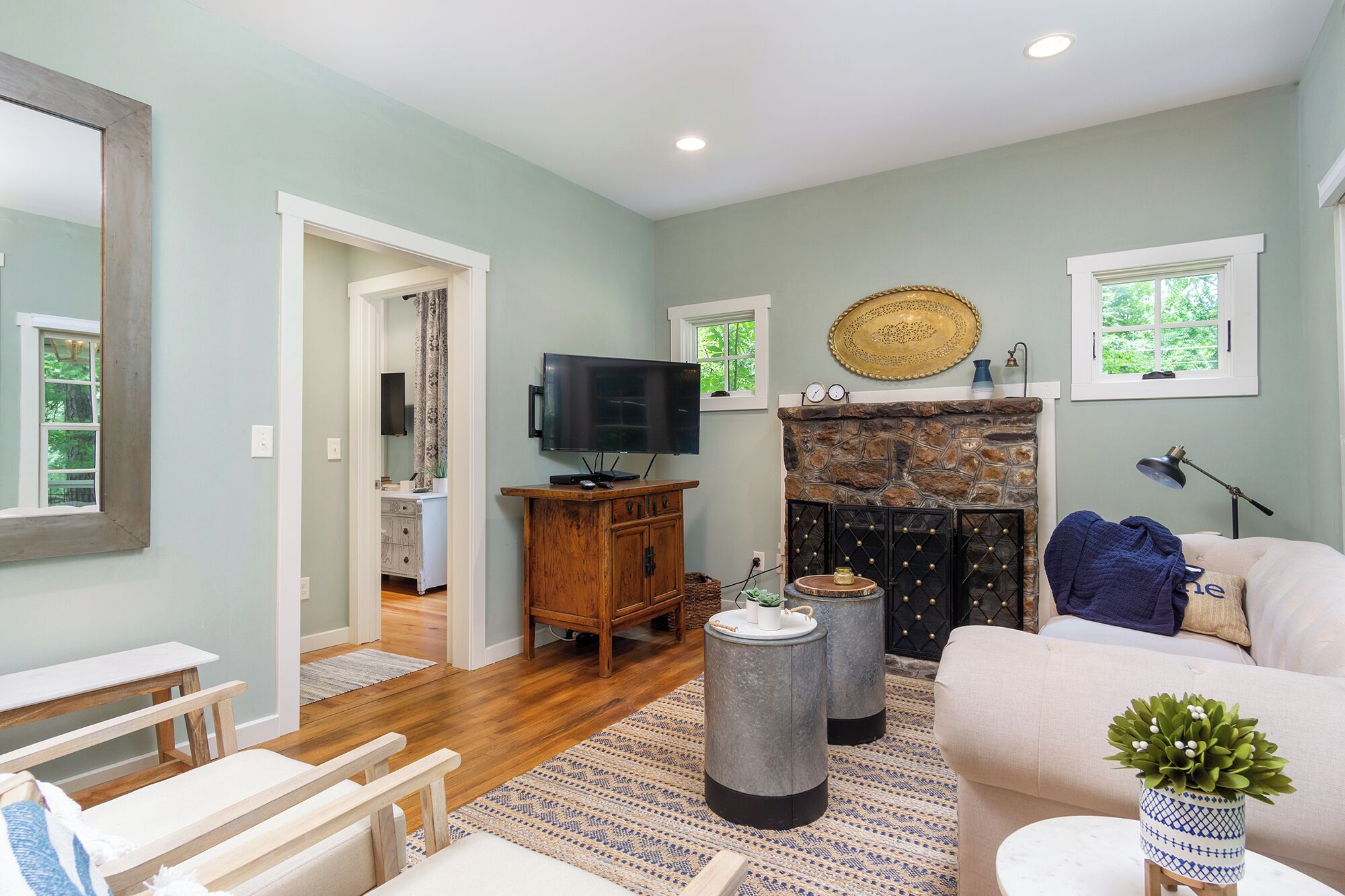 A living room with a stone fireplace, a television, and a sofa.