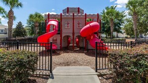 A playground with two red slides and a castle-like structure. - Budget Friendly Condo in Windsor Hills Resort w garden view (Kissimmee)