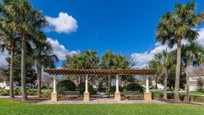 A gazebo with a tiled roof, surrounded by palm trees and a well-maintained lawn. - Budget Friendly Condo in Windsor Hills Resort w garden view (Kissimmee)