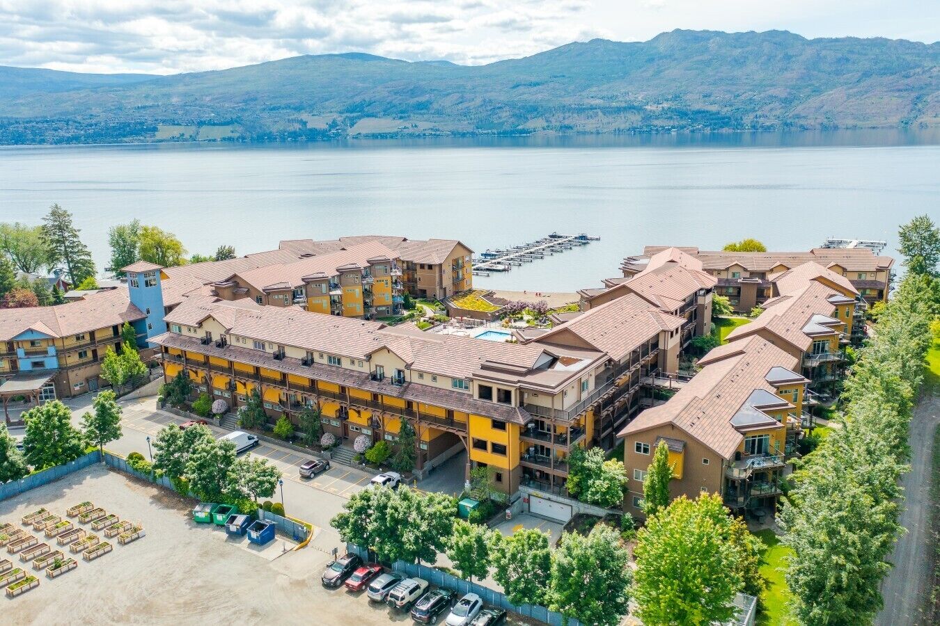 Ein mehrstöckiges Hotel mit Innenhof, umgeben von Wasser und Bergen im Hintergrund.