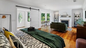 Una camera da letto moderna con un letto, un divano, un camino e vista sull'esterno.