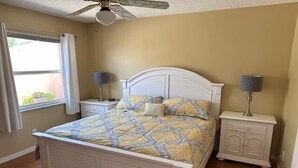 A bedroom with a bed, two bedside tables, a ceiling fan, and a window with curtains. - 2 bed/2bath Courtyard Villa Spanish Springs w/cart (The Villages)