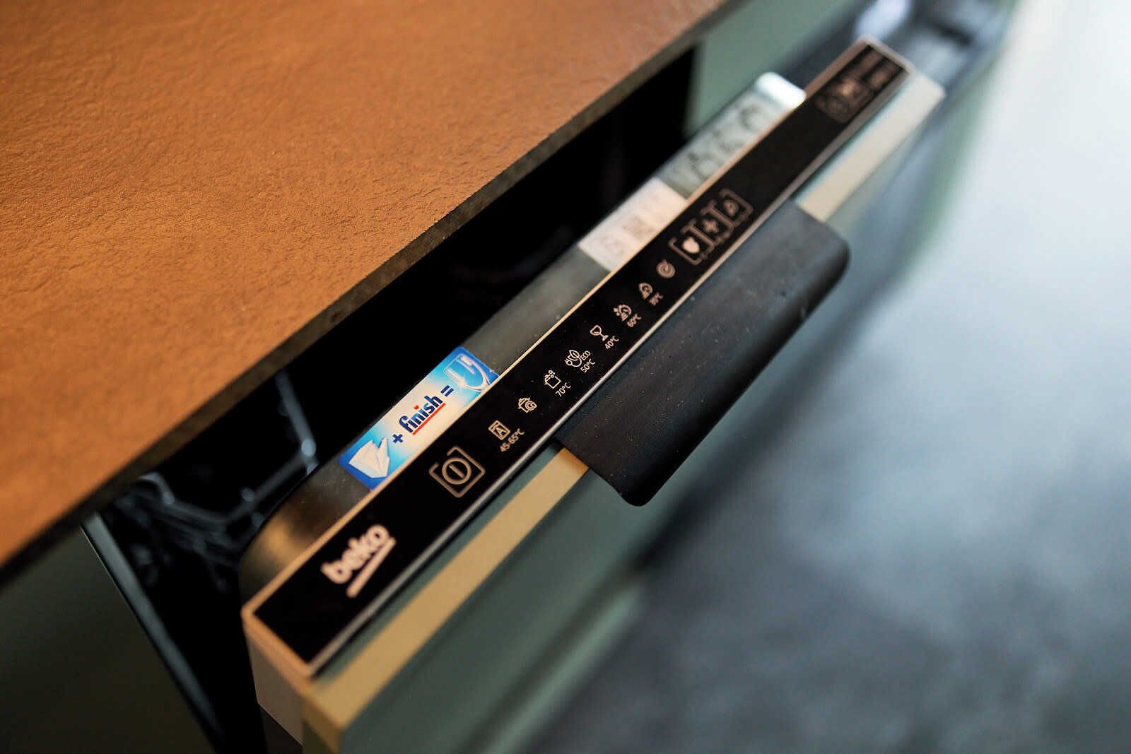 A drawer with a black handle and a control panel with icons and a "finish" button.