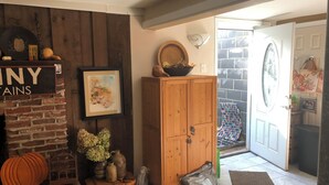 Ein rustikales Interieur mit Kamin aus Ziegelsteinen, Holzausbau und einer Tür, die nach draußen führt.