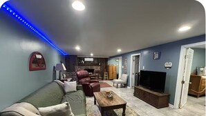 Ein Wohnzimmer mit einer Couch, einem Couchtisch, einem Fernseher und einem Kamin.