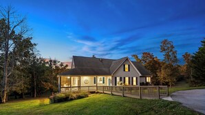 A two-story house with a covered porch, a fenced yard, and a driveway. - Stunning Views, Riverfront Privacy, 18-Acre Estate - Near Hikes, Wine/Breweries! (Charles Town)