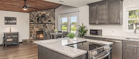 Una cocina moderna con encimeras de granito, electrodomésticos de acero inoxidable y armarios oscuros.