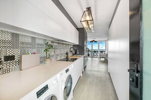 Enjoy cooking in this sleek kitchen with a central island, washing machine, and large window offering a view of the outdoors.