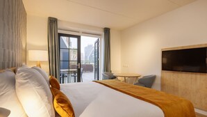 A hotel room with a bed, a TV, a table, and a view of the outside. - Nice Hotel Room Only 1 km From Volendam Centre (Volendam)