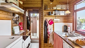 A compact kitchen with wooden walls, a built-in oven, and a sink. - Amazing home in Væggerløse with WiFi (Væggerløse)