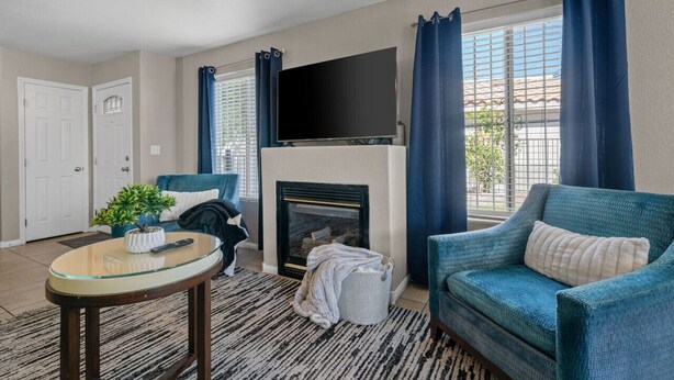 Ein Wohnzimmer mit Kamin, Fernseher, Sofa und Couchtisch.