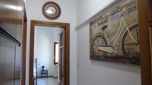 A hallway with a bicycle-themed wall art, a wooden door frame, and a tiled floor. - Homiday - Il Moro Residence (Roseto degli Abruzzi)