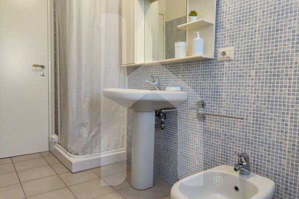 A bathroom with a white sink, a mirror, and a shower curtain. - Casa Ingrid is an exclusive solution, in the heart of the tourist area of Scerne, about 5 km from the center of Pineto. The entrance leads to a large living room with a fully equipped kitchen with access to the well-equipped balcony to enjoy time o (Pineto)